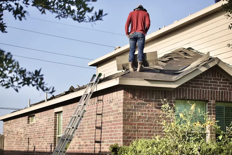 Professional roofer working on a residential roof in Watford City
